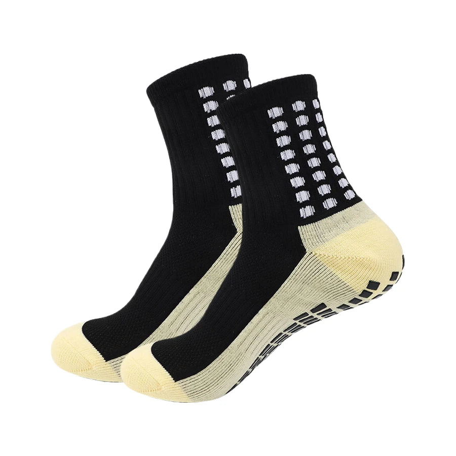 Ein Paar schwarze und beige Sport-Grip-Socken von der Seite.