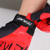 Close-up of a red and black cycling riding glove with a black strap featuring the Fistplast logo.