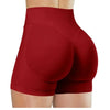 Gros plan sur une femme portant des short de yoga sans couture à taille haute de couleur rouge profond.