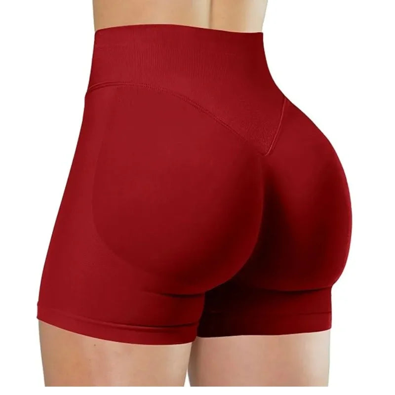 Gros plan sur une femme portant des short de yoga sans couture à taille haute de couleur rouge profond.