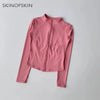 A pink long-sleeved zip-up jacket for yoga and fitness, shown flat lay.