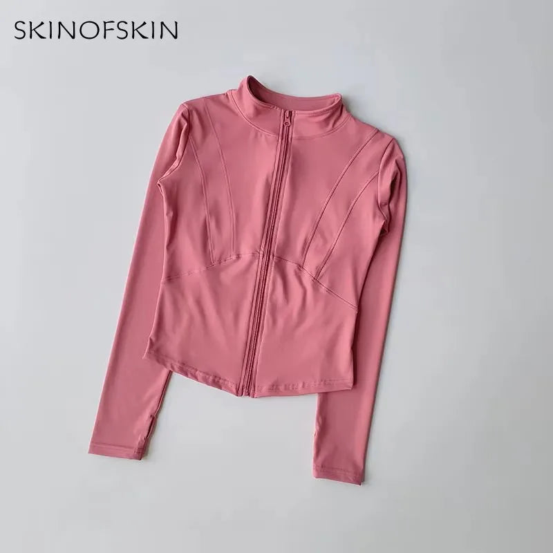 A pink long-sleeved zip-up jacket for yoga and fitness, shown flat lay.