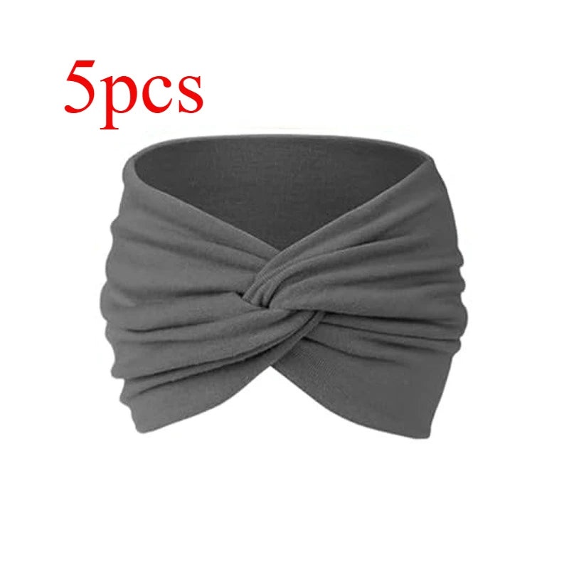 Una diadema de tela gris doblada en un nudo, adecuada para fitness o yoga.