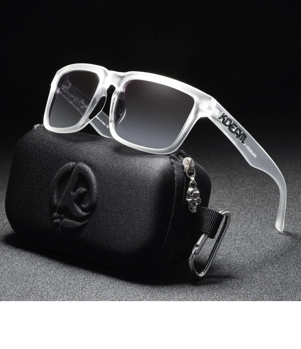 Klare, polarisierte Sonnenbrille aus Kunststoff liegt auf einer schwarzen Tasche mit silberner Schnalle.