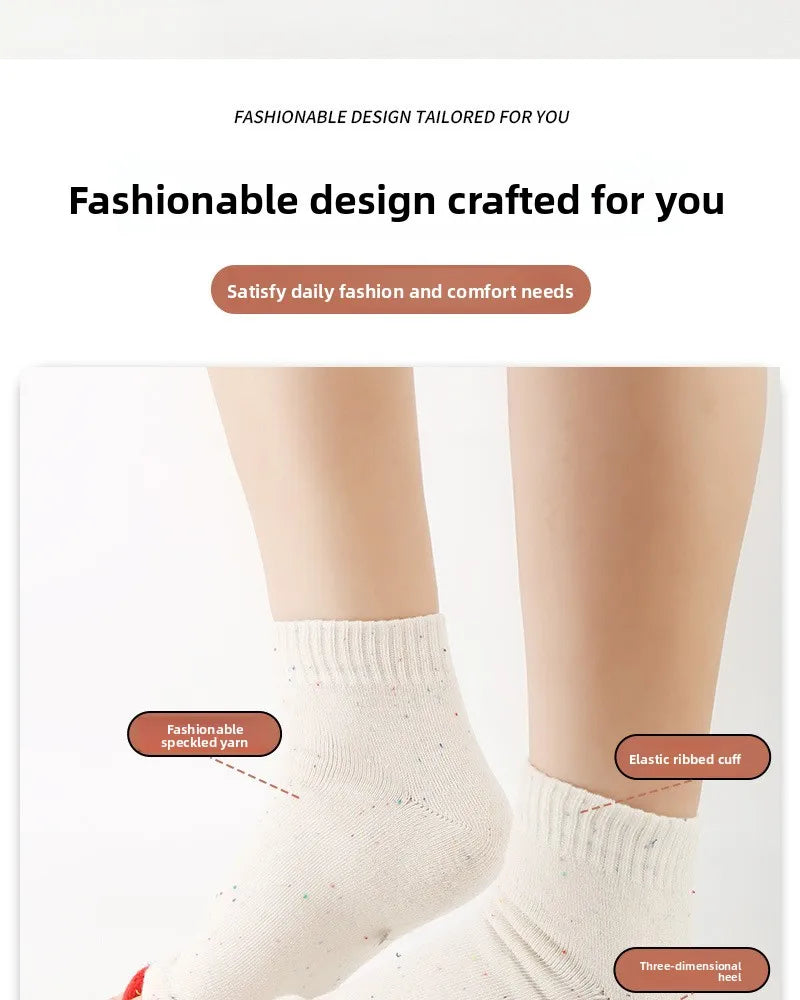 Close-up of white speckled elastic ribbed socks worn on a leg.