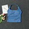A royal blue seamless yoga and pilates sports bra laid on a dark gray fabric with pink and white flowers.