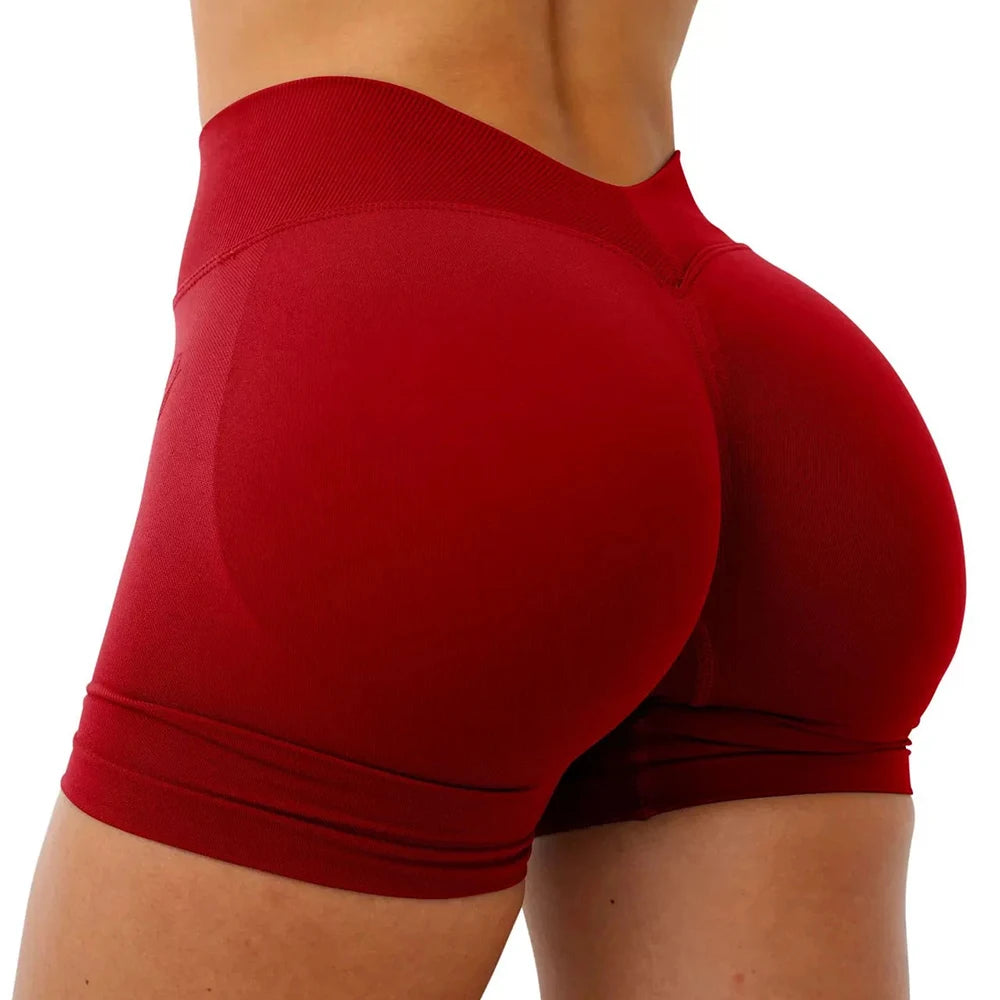 A close-up view of a woman wearing seamless red yoga shorts for fitness and workout.