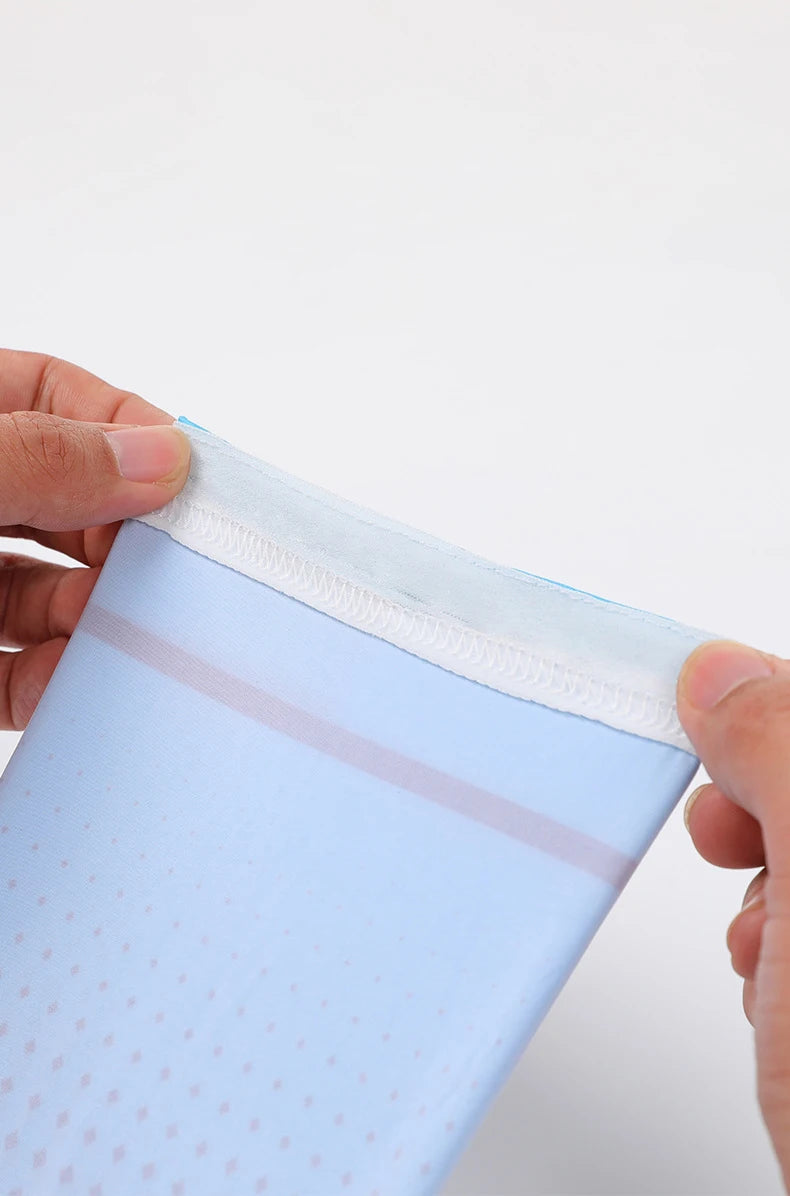 A hand is holding a light blue UPF 50+ cool sleeve for outdoor sports, showing the elastic cuff.