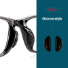 A pair of black silicone anti-slip eyeglass nose pads in a groove style.