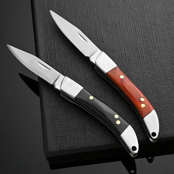 A stainless steel folding knife with a wooden handle resting on a dark surface.