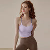A woman wearing a light purple supportive sports bra and brown leggings posing for a photo.