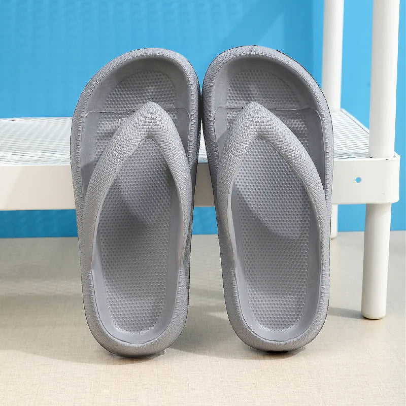 A pair of gray comfort platform flip flops resting on a white wooden surface.