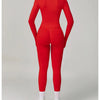 Eine Frau trägt ein rotes, nahtloses Sport-Yoga-Set mit langärmeligem Oberteil und Leggings.