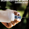 A hand holds a clear silicone hydration flask, designed for sports use, against a dark, blurred background.