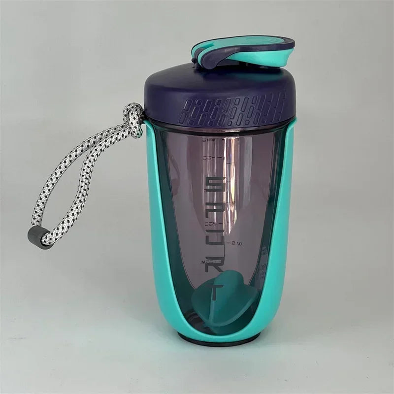 A purple and teal blender shaker bottle with a mesh lid and a looped silicone strap.