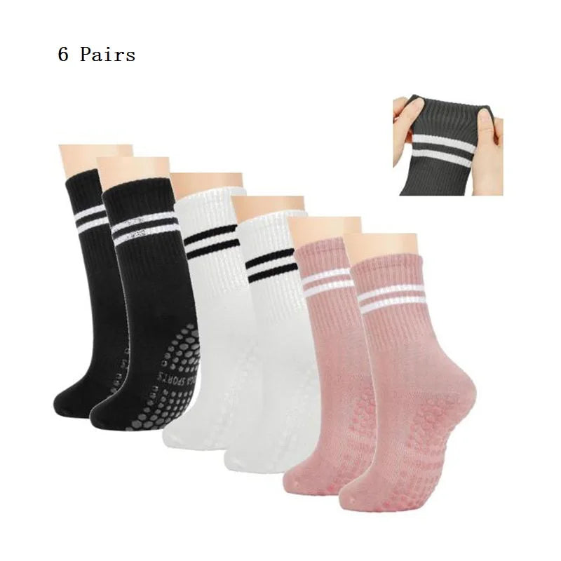 Six pairs of black, white, and pink grip socks for yoga and barre