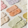 Collection de chaussettes de yoga et de fitness respirantes dans diverses nuances pastel, dont rose, pêche, crème et vert cla