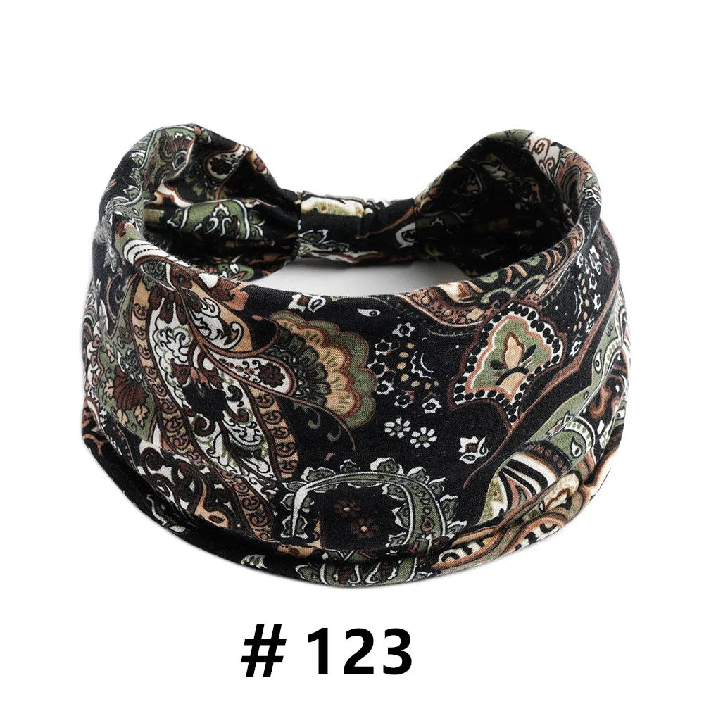 A black and beige boho print cotton headband tied in a bow.