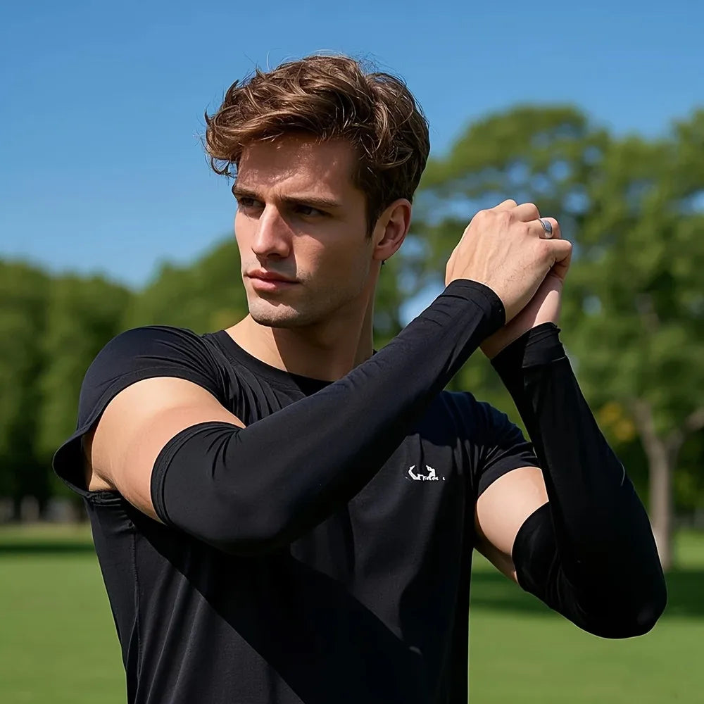 A young man wearing black sun protection arm sleeves outdoors.