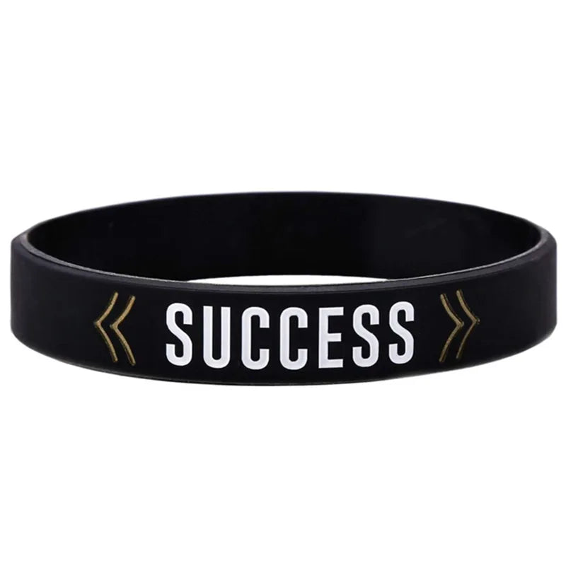 Black silicone wristband with the word SUCCESS printed in white text and gold arrows.