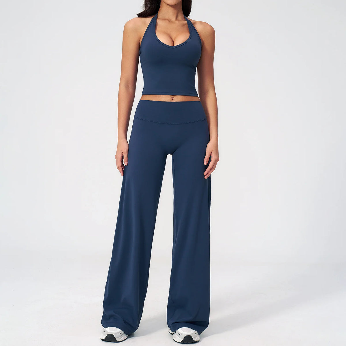 A woman wearing a navy blue women's premium fitness tracksuit top and matching pants.