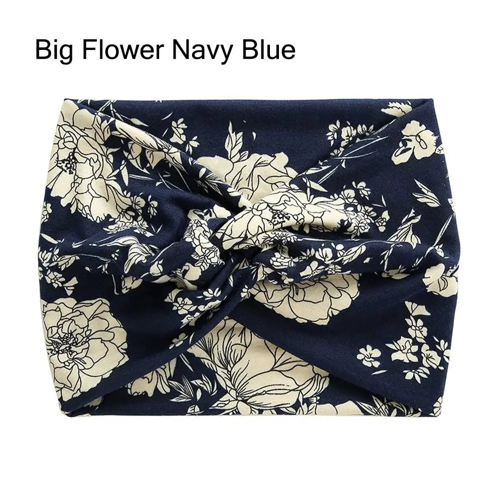 Navy blue fabric headband with a floral pattern, cross-knotted and folded.