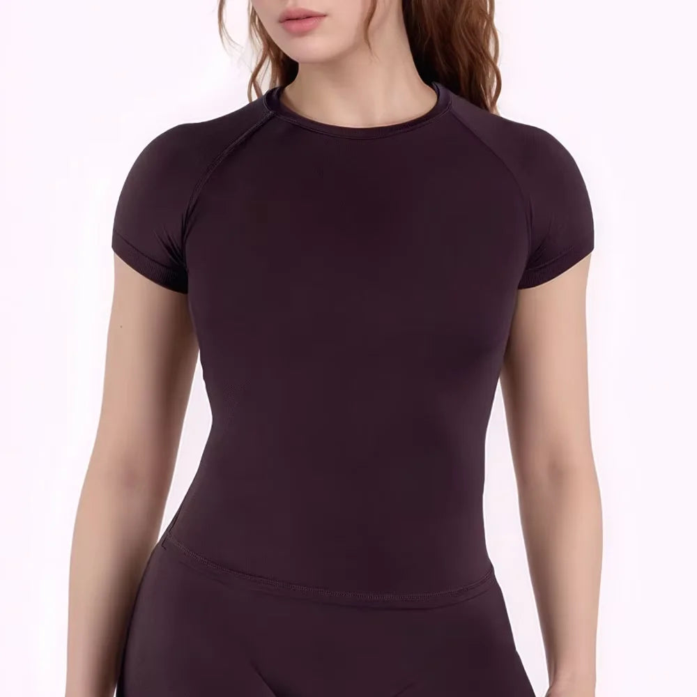 A dark plum performance fitness short sleeve top for women shown on a model.