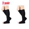 A pair of black compression zippered stockings shown on a model's legs.