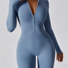 Modelin trägt einen langärmeligen, hellblauen, eng anliegenden Zip-Overall.