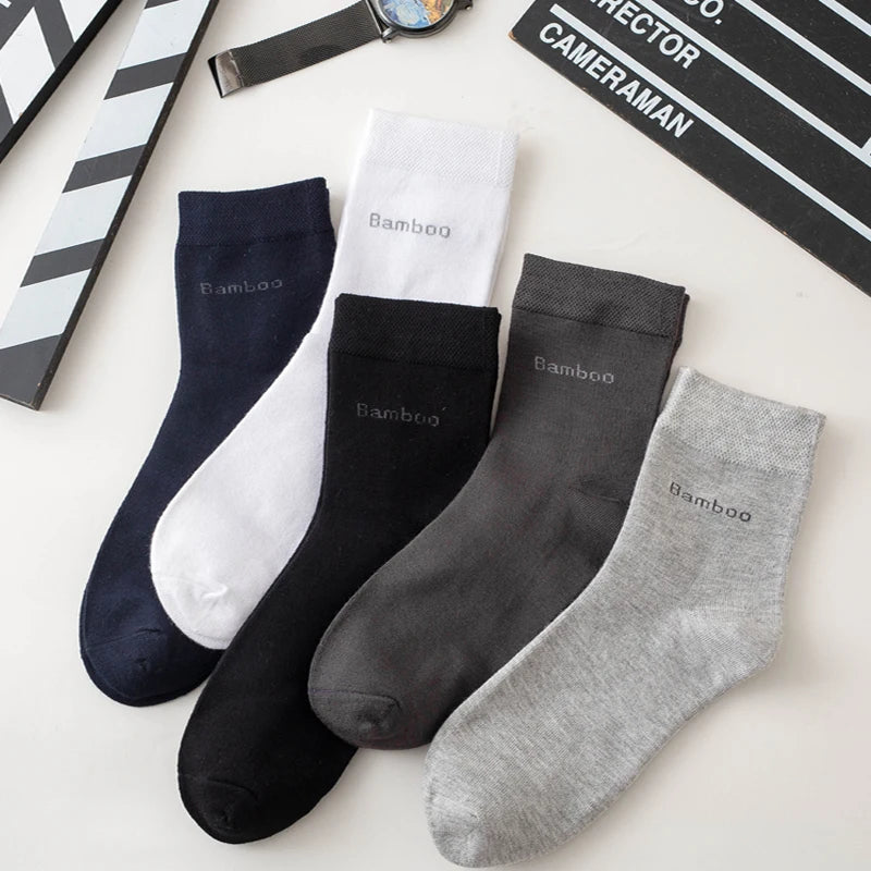 A collection of five bamboo fiber socks in black, white, and gray are displayed on a light surface.