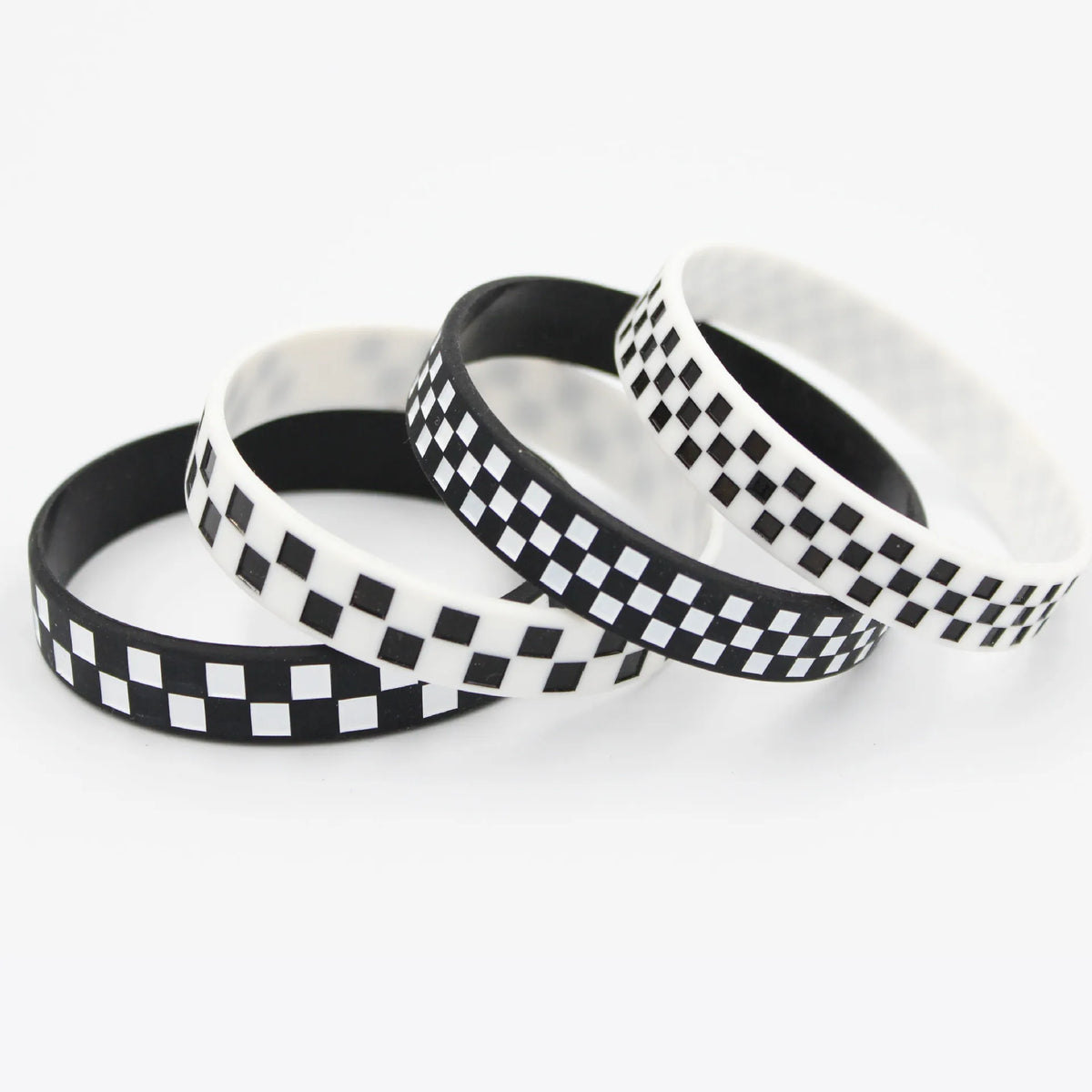 Three checkered silicone wristbands in black and white are displayed on a white background.