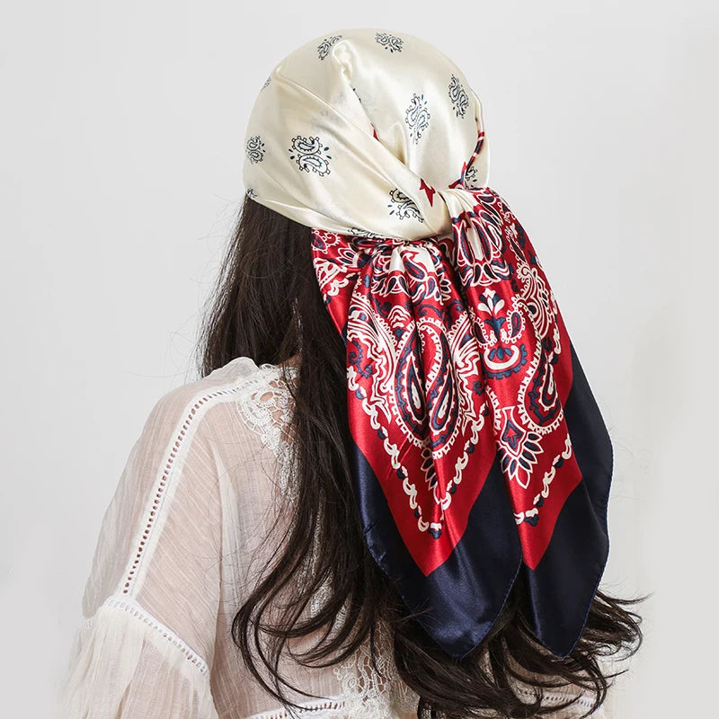 A woman is shown from the back wearing a silk paisley shawl scarf wrapped around her hair.