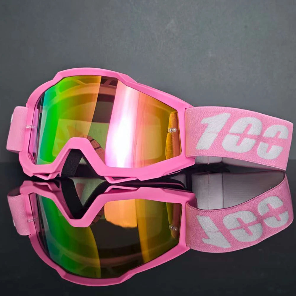 Gafas de motocross rosas con lentes iridiscentes y correa rosa, vistas desde arriba.