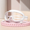 Gafas de natación blancas antiempañante sobre un soporte circular rosa.