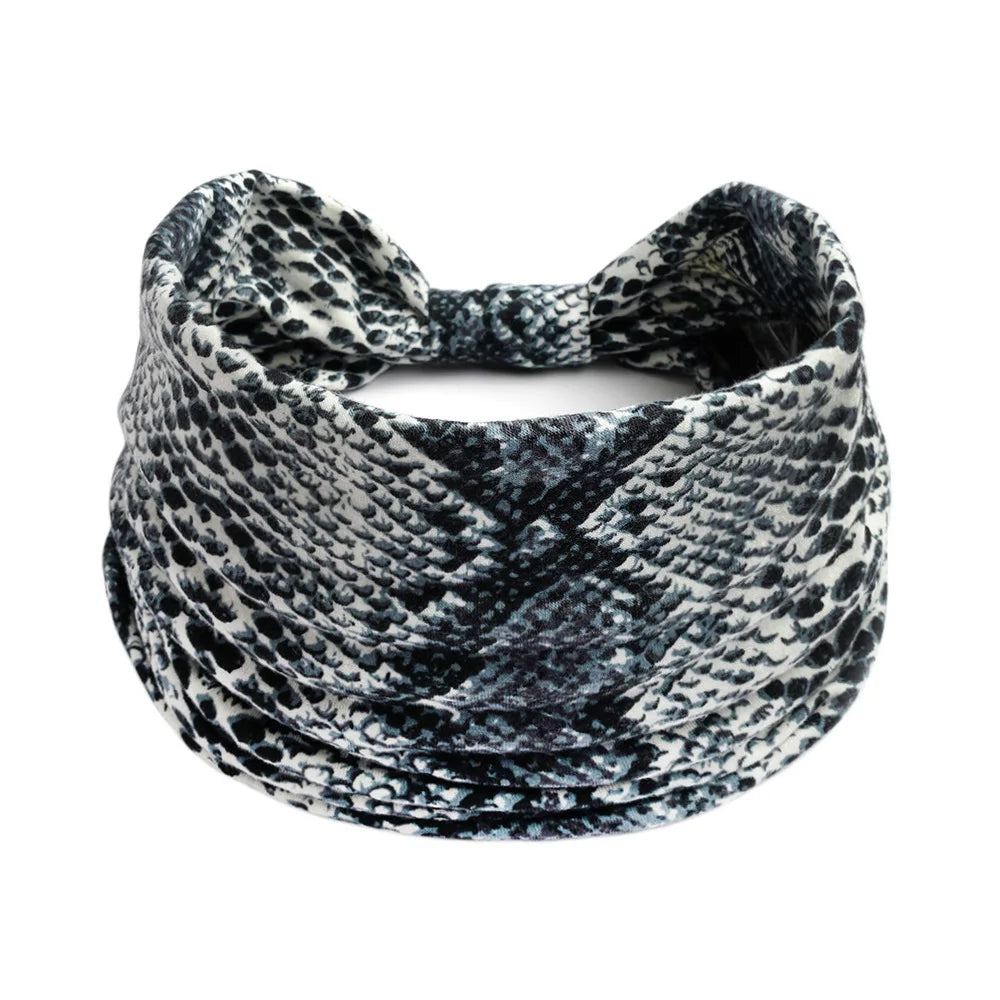 A black and white patterned bohemian cotton stretch headband tied in a knot.