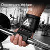 A hand grips a chrome barbell with a black wrist wrap featuring a triangular grip for heavy weight lifting.