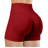 Gros plan d'une femme portant des short de yoga sans couture taille haute de couleur rouge foncé.