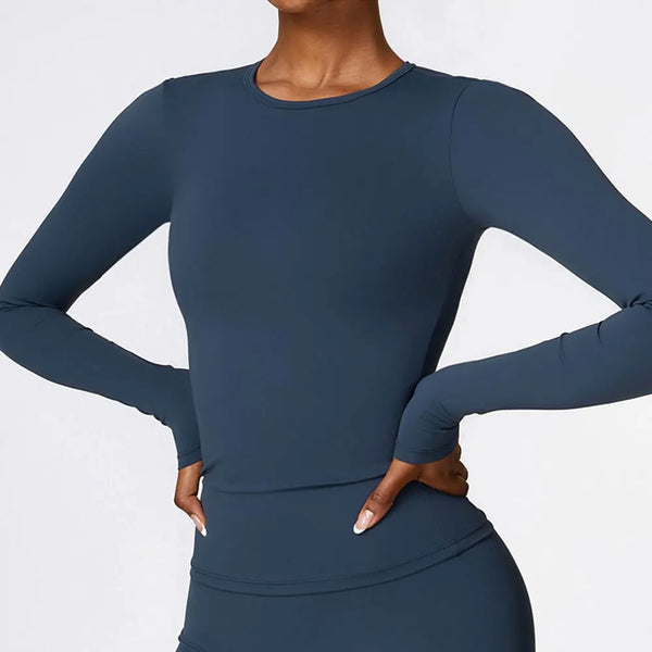 Une femme portant un t-shirt de yoga et de fitness bleu marine à manches longues.
