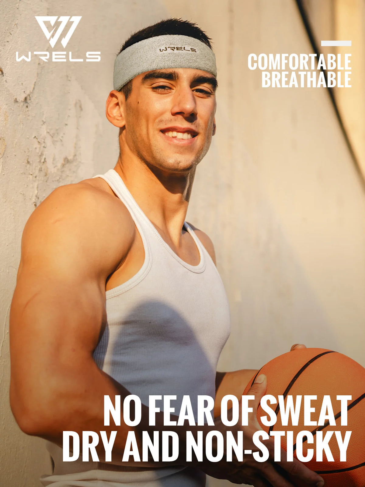 A muscular man wearing a grey Wrels sweatband and a white tank top, posing outdoors.