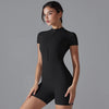 A model wearing a black seamless yoga jumpsuit, shown from the front.