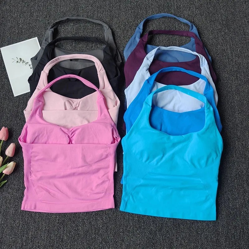 A collection of seamless yoga and pilates sports bras in various colors including black, pink, purple, blue, and gray.