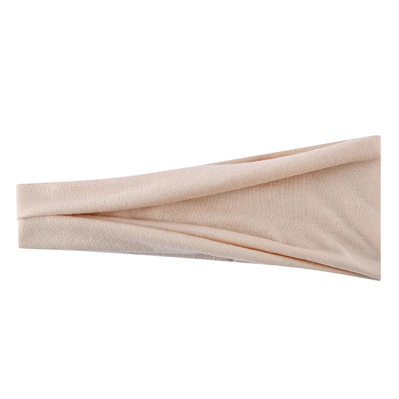 Un bandeau élastique beige plié et exposé sur un fond blanc.
