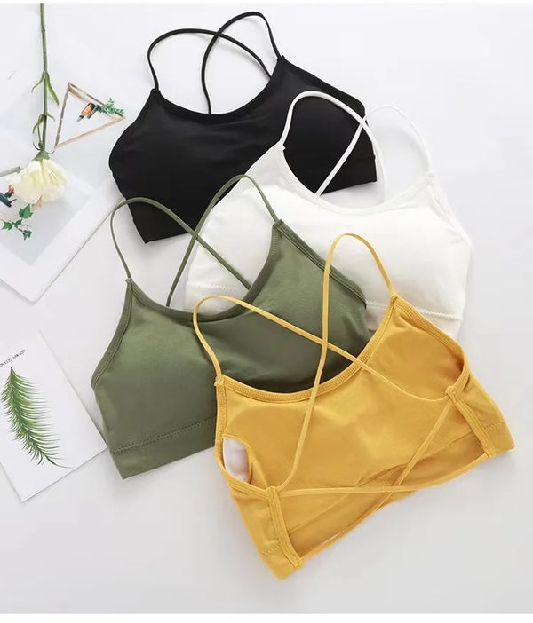 Colección de sujetadores deportivos de tirantes para mujeres en negro, blanco, verde oliva y amarillo sobre una superficie bl