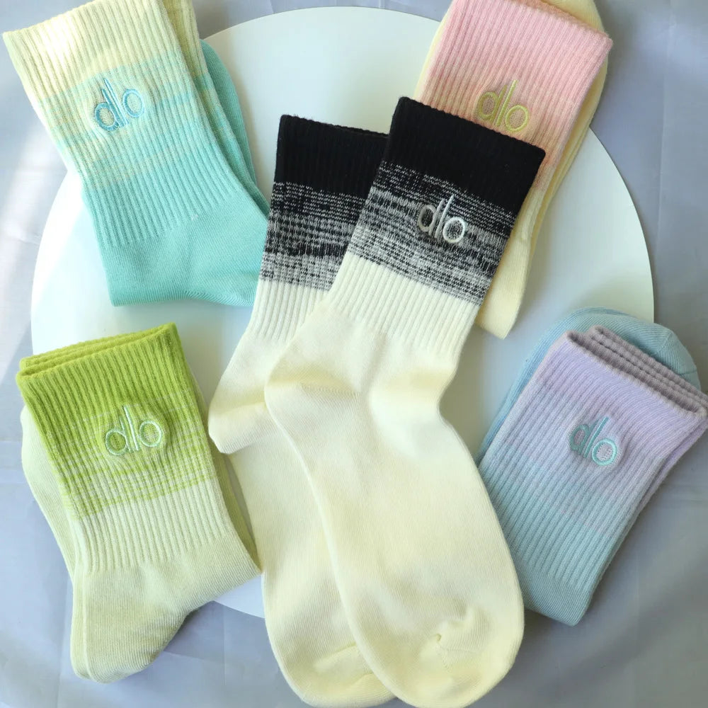 A collection of pastel and black cotton winter socks displayed on a white surface.