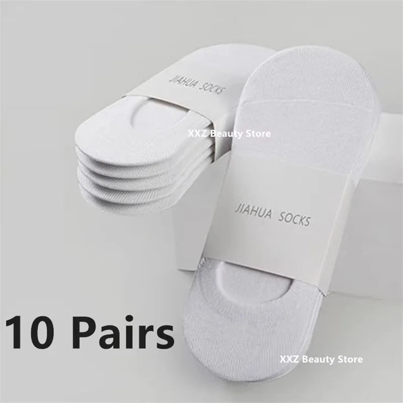 A stack of ten pairs of white boat socks for men and women displayed on a white background.