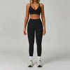 Eine Frau modelliert ein schwarzes, nahtloses Sport-Yoga-Set mit Crop-Top und Langhosen.