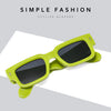 A pair of lime green sunglasses with thick frames and dark lenses resting on a white surface.
