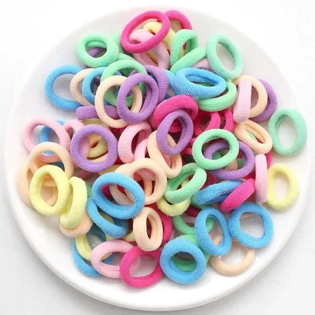 Haufen bunter Nylon-Elastik-Haargummis in verschiedenen Rosa-, Lila-, Blau- und Grüntönen