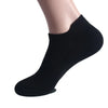 Schwarze Knöchelsocken auf einem Fuß eines Menschen.