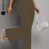 A model wearing olive brown flared yoga trousers and a white shoulder bag.
